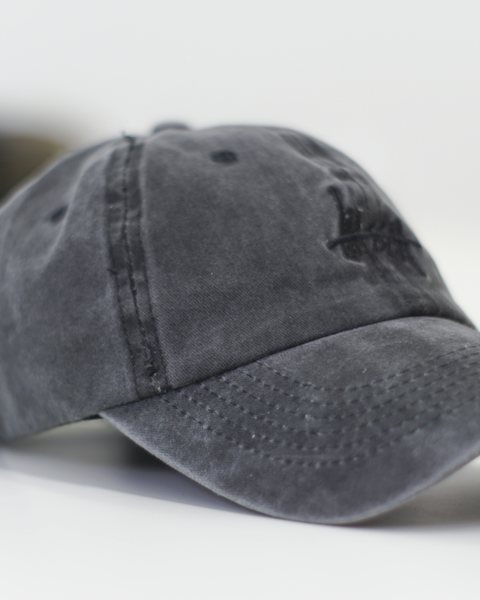 Washed black six-panel cap on a white surface