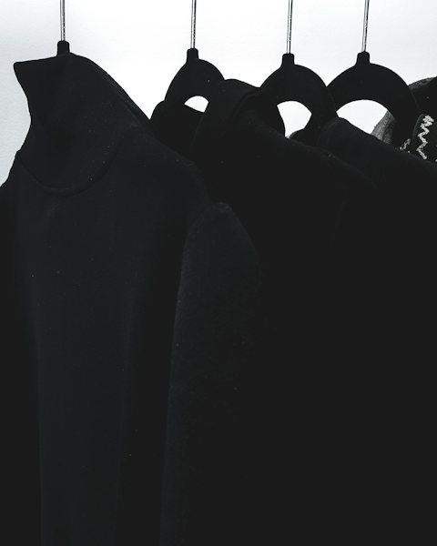 Black hoodies hanging in a row on a rail