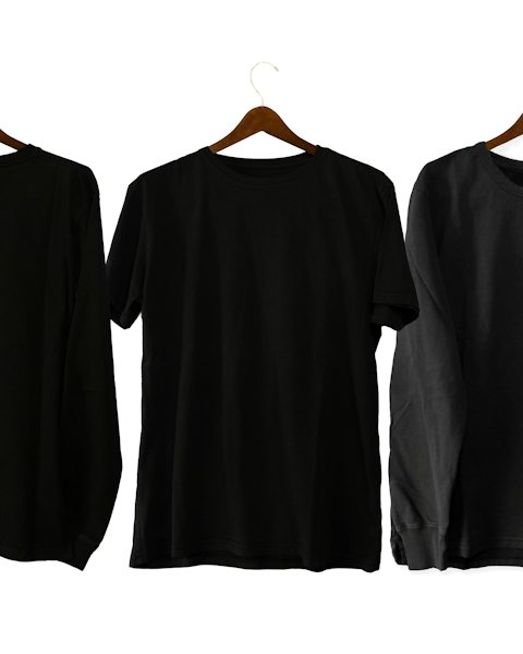 Three black t-shirts on hangers