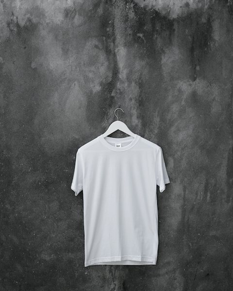 Plain bone white t-shirt hanging on a concrete wall